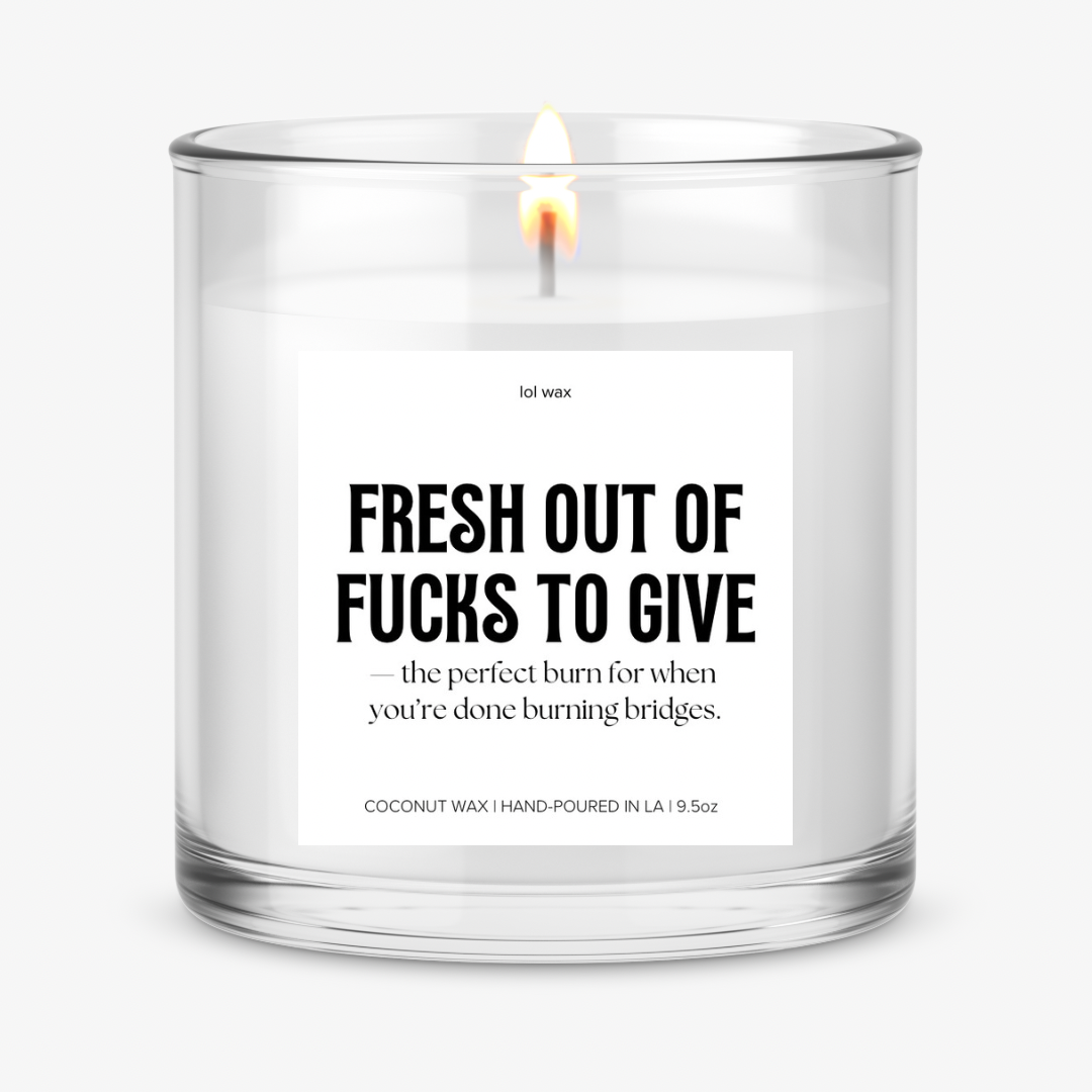 Clear glass candle with 'Fresh Out of Fucks to Give' label by lol wax, featuring a bold statement on a white background.